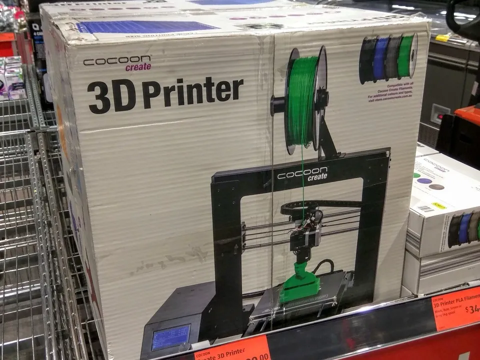 A boxed Cocoon Create 3D printer on a supermarket display at ALDI, with a $499.00 shelf tag and a red Special Buys sign below it.