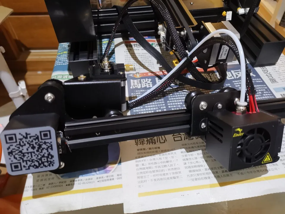 The X-axis gantry of a Creality Ender 3 during assembly: the toolhead carriage on wheels riding an aluminum extrusion, with the motor end of the axis at left